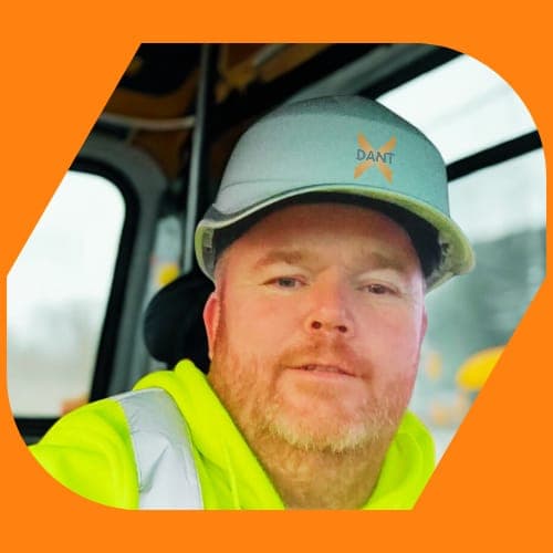 Paul Davis, DantX founder — in a DantX hard hat in the cab of an excavator