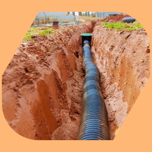 A DantX crew laying drainage in a dug service trench on an active Irish site