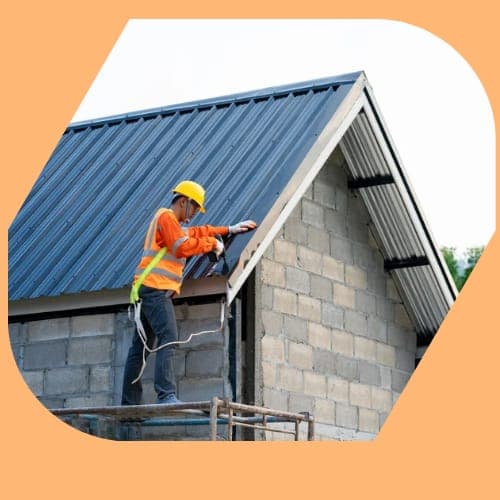 A DantX roofer fitting a new metal roof on a block-built home